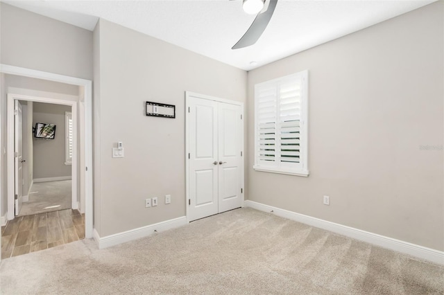 unfurnished bedroom with light carpet, a closet, and ceiling fan