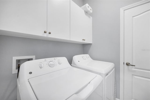 laundry area with washer and clothes dryer and cabinets