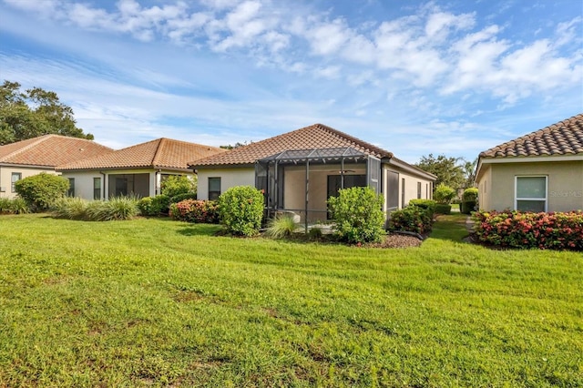 back of property featuring a sunroom and a yard