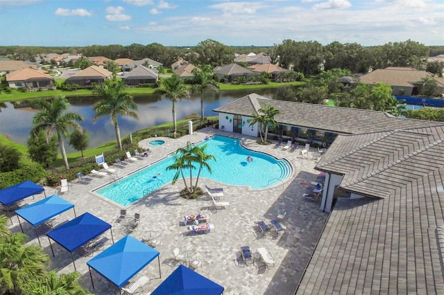 view of pool featuring a water view and a patio area