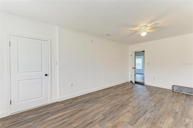 spare room featuring ceiling fan, crown molding, and dark wood-type flooring