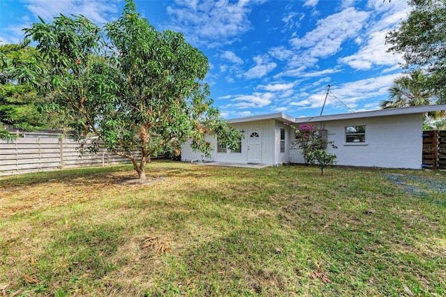 back of house featuring a lawn