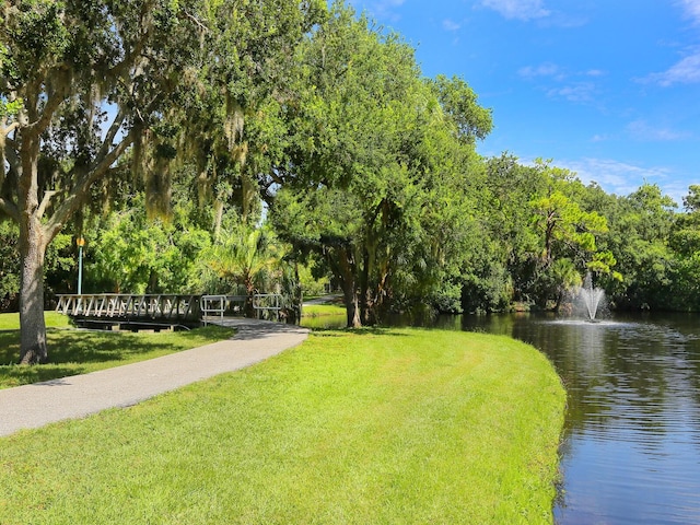 view of property's community with a yard and a water view