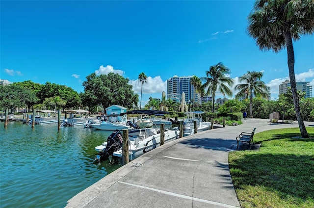 view of dock with a water view and a lawn