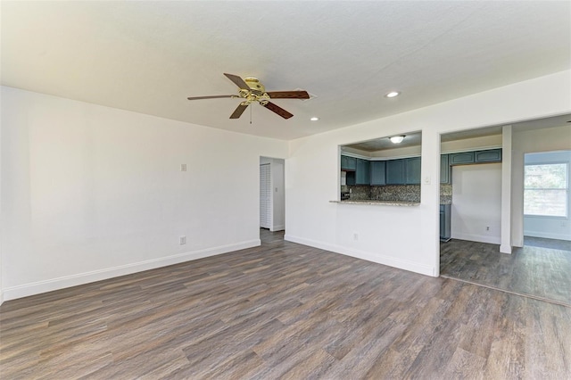 unfurnished living room with ceiling fan and dark hardwood / wood-style floors