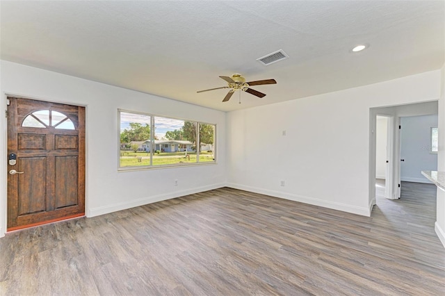 foyer with dark hardwood / wood-style floors, ceiling fan, and a textured ceiling