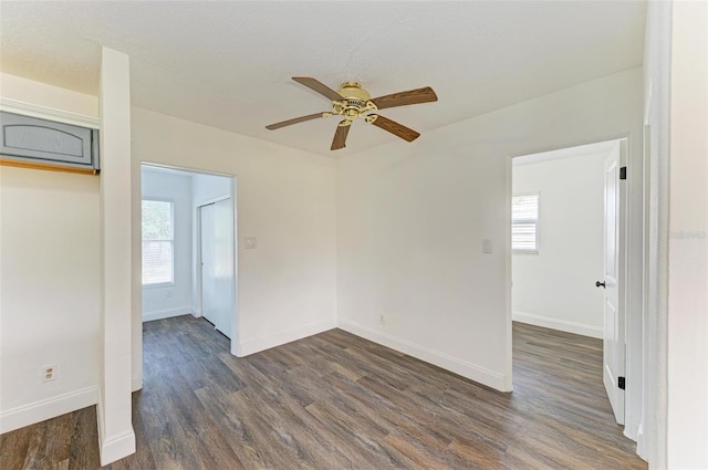 spare room with a textured ceiling, ceiling fan, and dark wood-type flooring