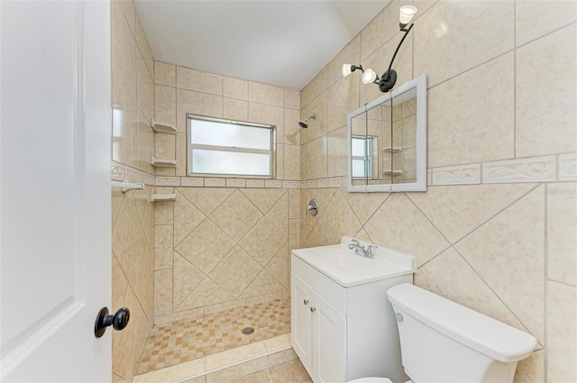 bathroom with vanity, tiled shower, and tile walls