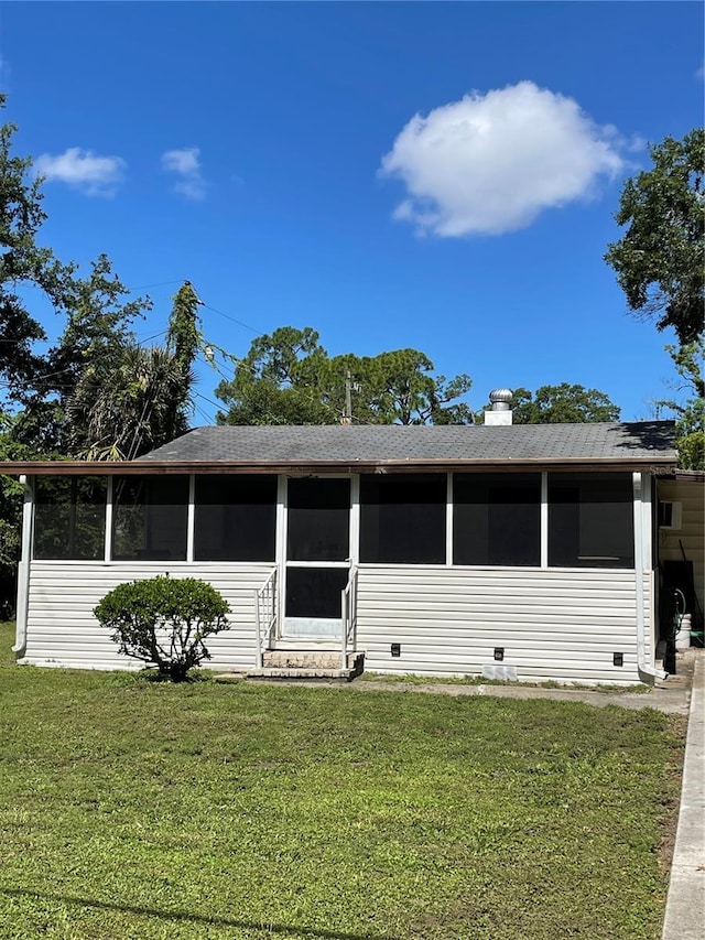 view of front of home with a sunroom and a front yard