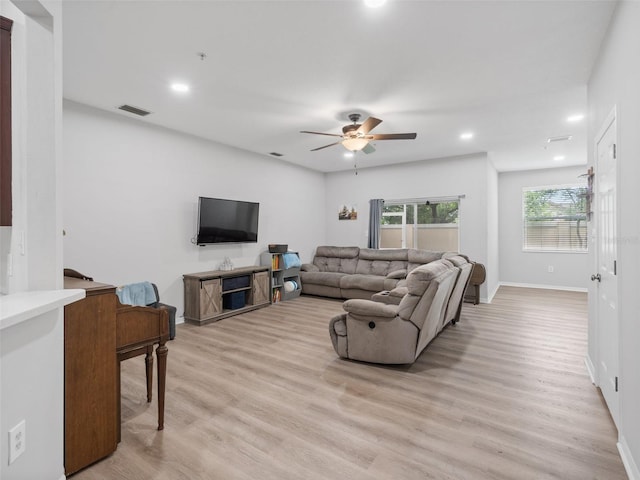 living room featuring ceiling fan and light hardwood / wood-style flooring