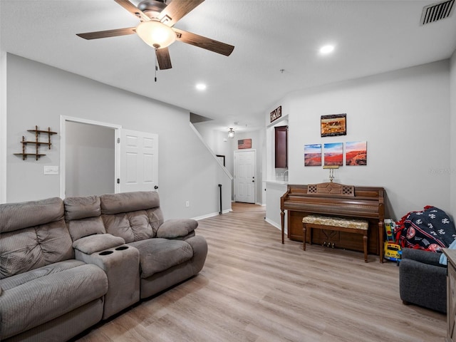 living room with ceiling fan and light hardwood / wood-style flooring