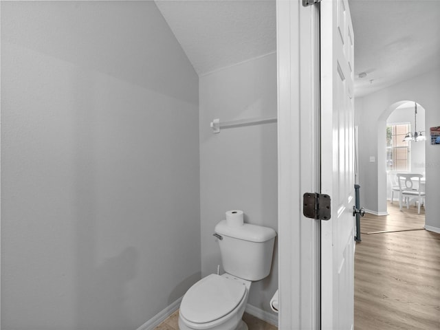 bathroom featuring a textured ceiling, toilet, hardwood / wood-style floors, and vaulted ceiling