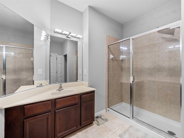 bathroom with tile patterned floors, walk in shower, and vanity