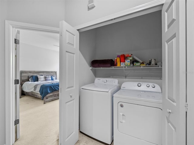 clothes washing area with light carpet and independent washer and dryer