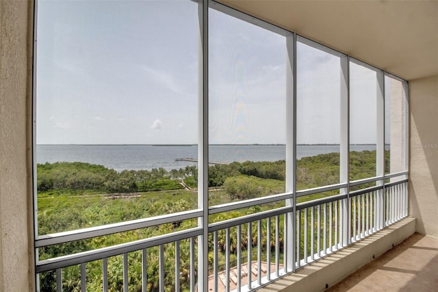 unfurnished sunroom with plenty of natural light and a water view