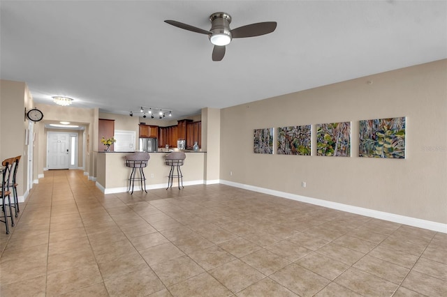 unfurnished living room featuring ceiling fan and light tile patterned floors