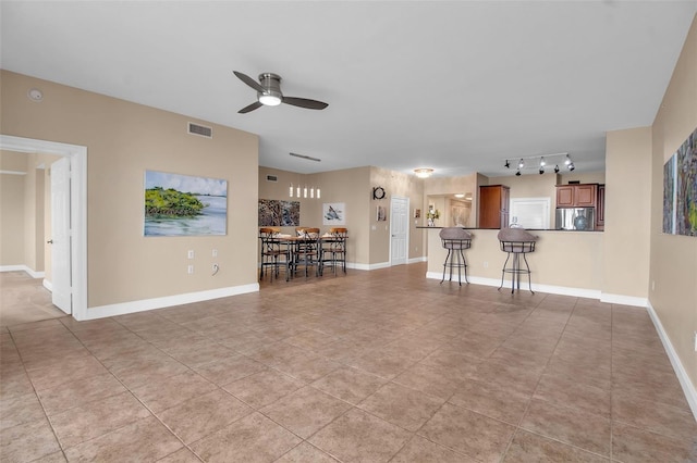 unfurnished living room featuring ceiling fan and light tile patterned floors