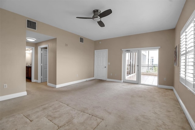 unfurnished room with light colored carpet and ceiling fan