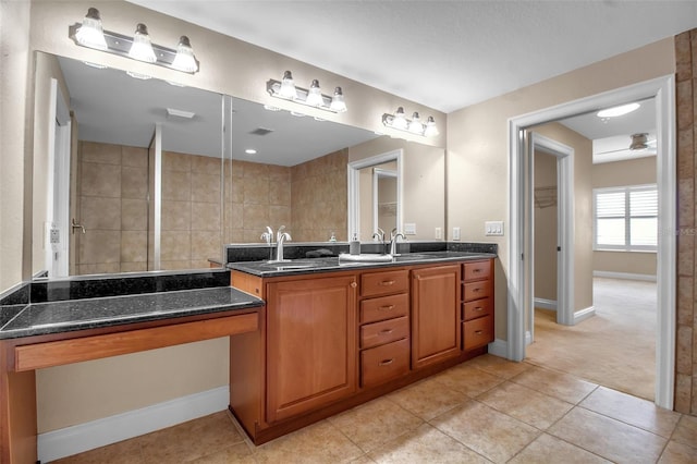 bathroom with tile patterned flooring, vanity, and walk in shower