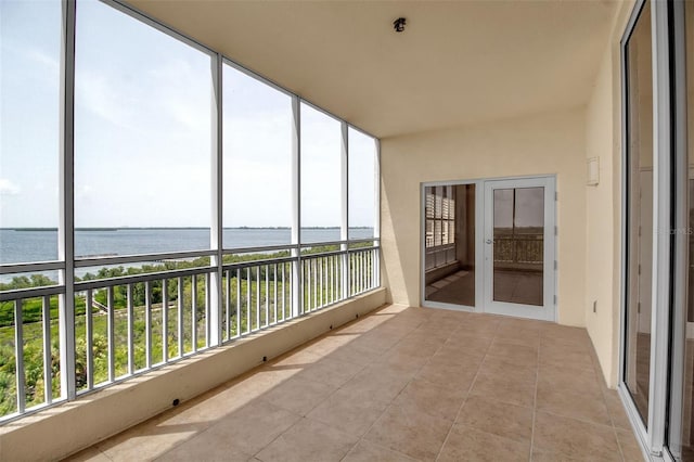 unfurnished sunroom featuring a water view