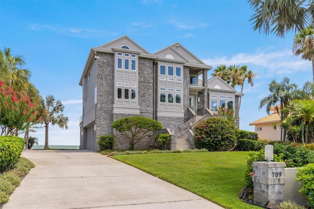 view of front of property with a balcony, a garage, and a front yard