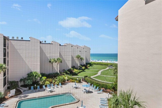 view of swimming pool featuring a patio and a water view