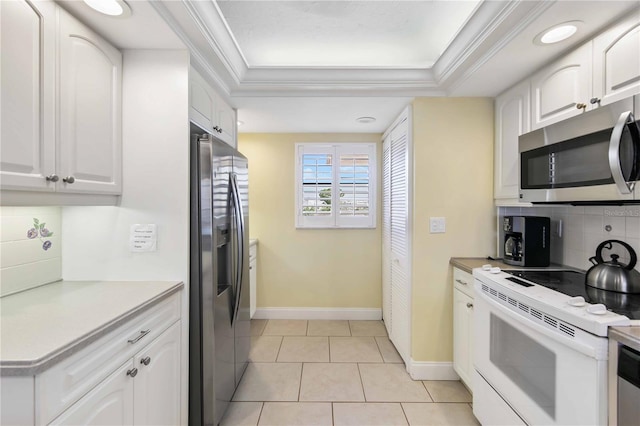 kitchen with a tray ceiling, appliances with stainless steel finishes, and crown molding