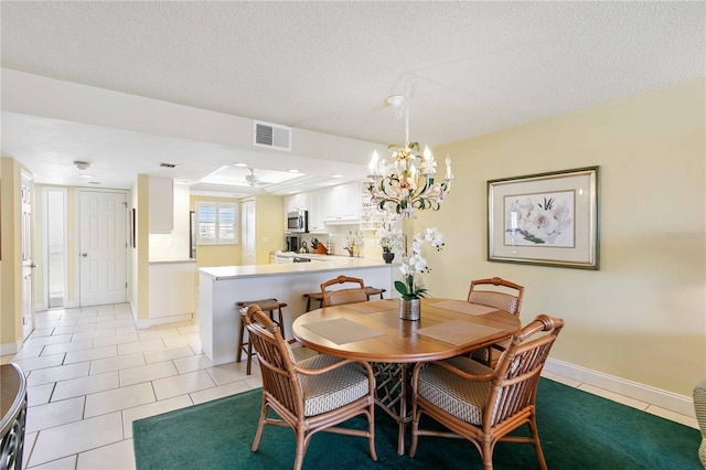 dining room with light tile patterned floors, a textured ceiling, visible vents, and baseboards