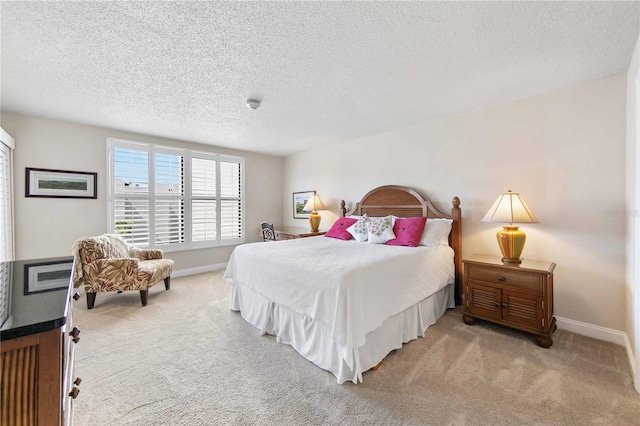 carpeted bedroom featuring baseboards and a textured ceiling