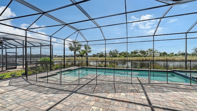 view of pool with a water view, glass enclosure, a pool with connected hot tub, and a patio