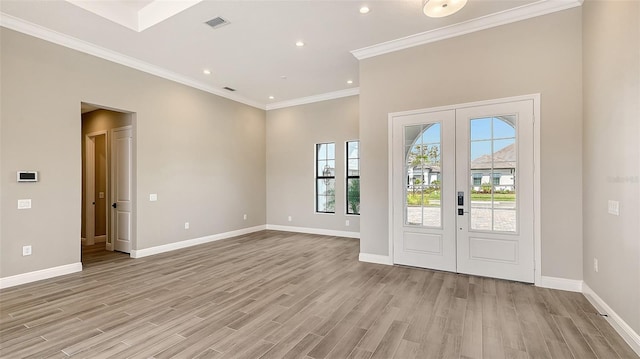 foyer entrance featuring baseboards, visible vents, crown molding, french doors, and light wood-type flooring