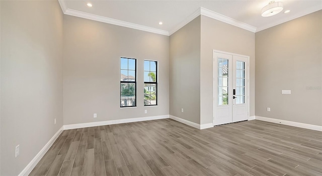 foyer with a healthy amount of sunlight, crown molding, baseboards, and wood finished floors