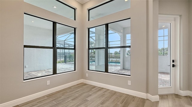 spare room with baseboards and wood finish floors