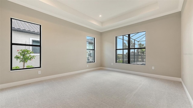 empty room with recessed lighting, baseboards, a tray ceiling, and light colored carpet