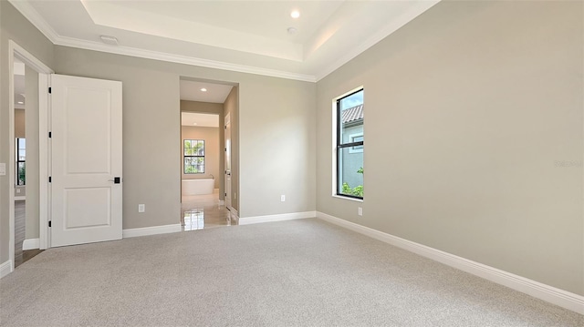 unfurnished bedroom featuring light carpet, a tray ceiling, recessed lighting, and baseboards