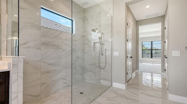 bathroom featuring marble finish floor, baseboards, a walk in shower, and vanity