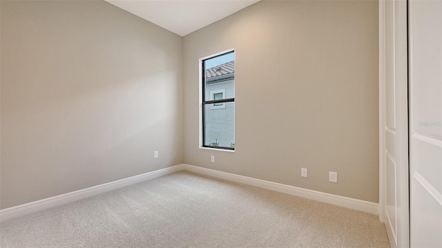 unfurnished room featuring baseboards and light colored carpet