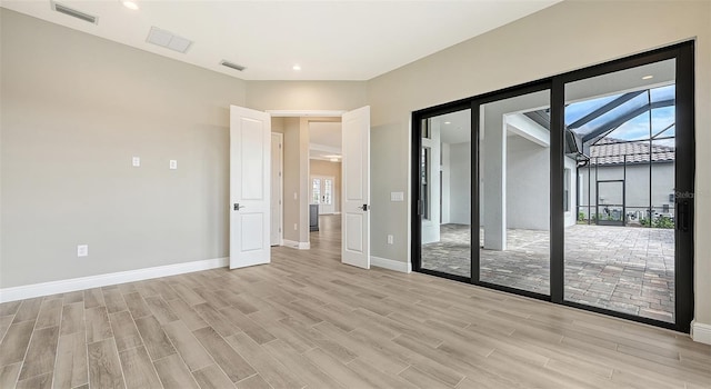 unfurnished room with baseboards, visible vents, and light wood finished floors