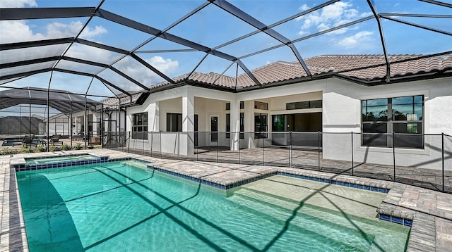 view of pool with a pool with connected hot tub, glass enclosure, and a patio