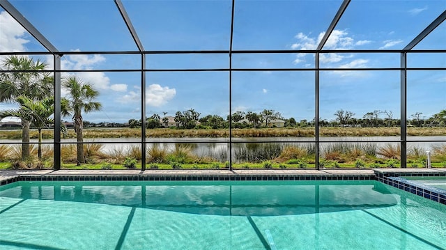 view of pool with glass enclosure, a water view, and a pool with connected hot tub