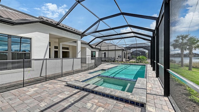 view of pool with a patio, a water view, a lanai, and a pool with connected hot tub