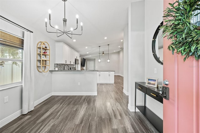 kitchen with decorative light fixtures, white cabinetry, tasteful backsplash, dark hardwood / wood-style floors, and kitchen peninsula