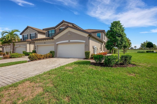 mediterranean / spanish home with a garage and a front lawn