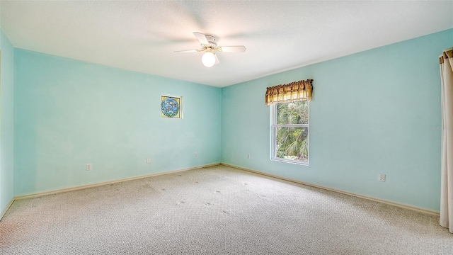 unfurnished room with ceiling fan and carpet