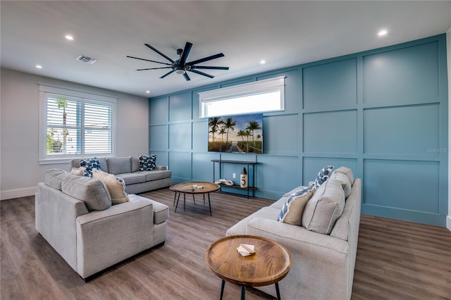 living room with ceiling fan and dark wood-type flooring