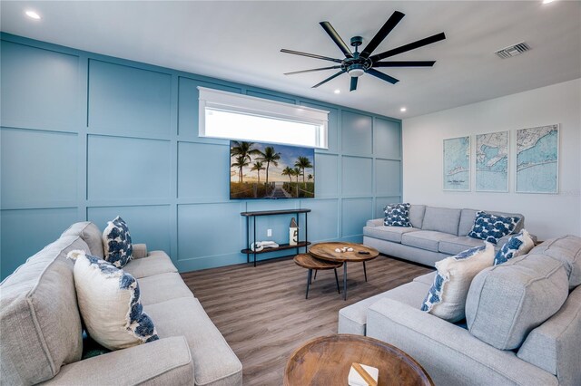 living room featuring ceiling fan and light hardwood / wood-style flooring