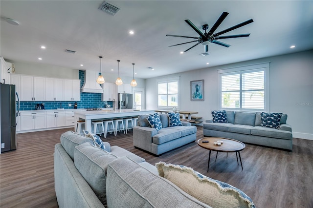 living room with ceiling fan and dark wood-type flooring