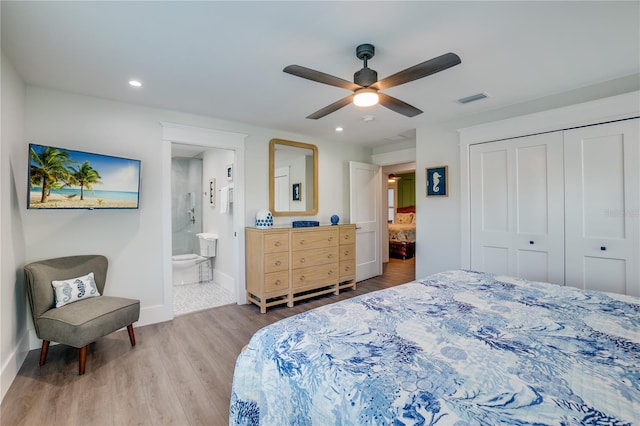 bedroom with ceiling fan, ensuite bath, light wood-type flooring, and a closet