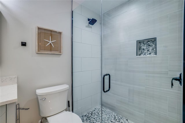 bathroom featuring vanity, toilet, and an enclosed shower