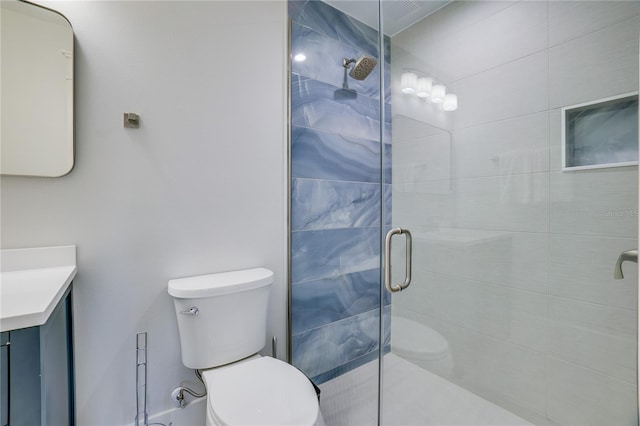 bathroom featuring vanity, an enclosed shower, and toilet